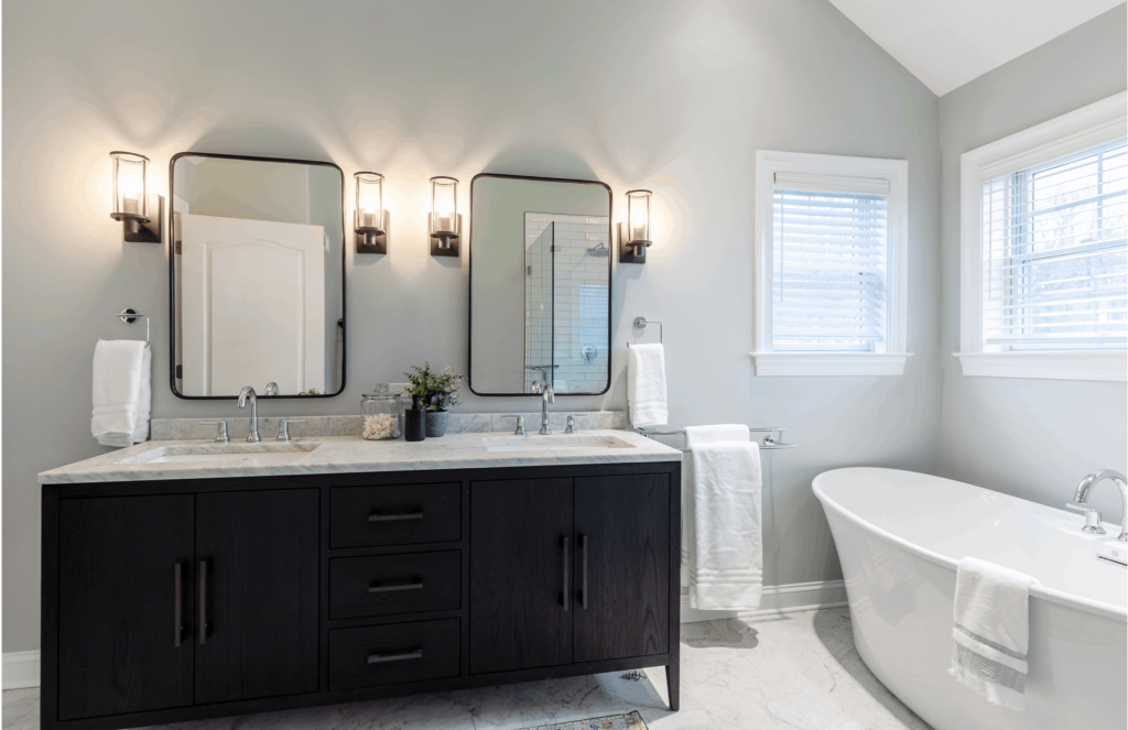 Contemporary master bath with double vanity, black cabinets, and stand-alone tub.