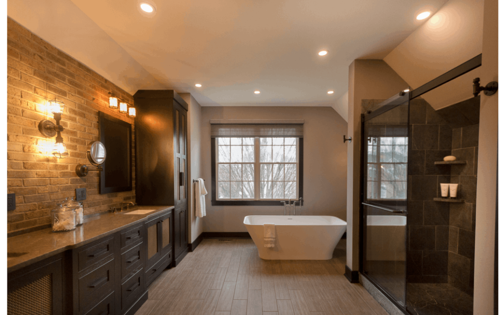 Enchanting rustic master bathroom with dark-tiled shower, rich wooden vanities, and stone accent wall