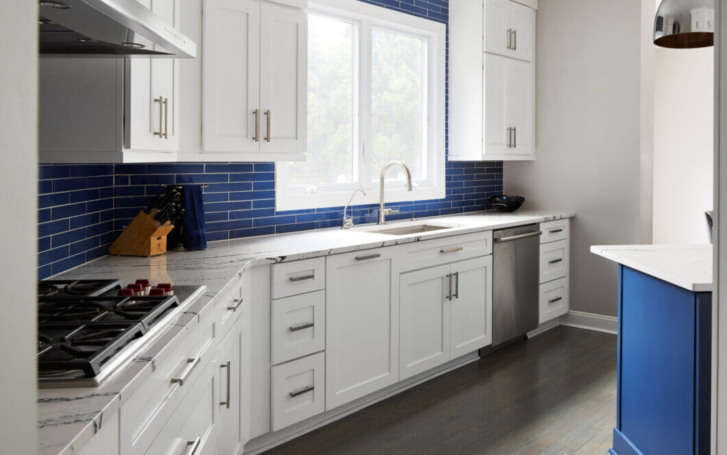 A custom kitchen remodel with blue subway tile backsplash and granite countertops.