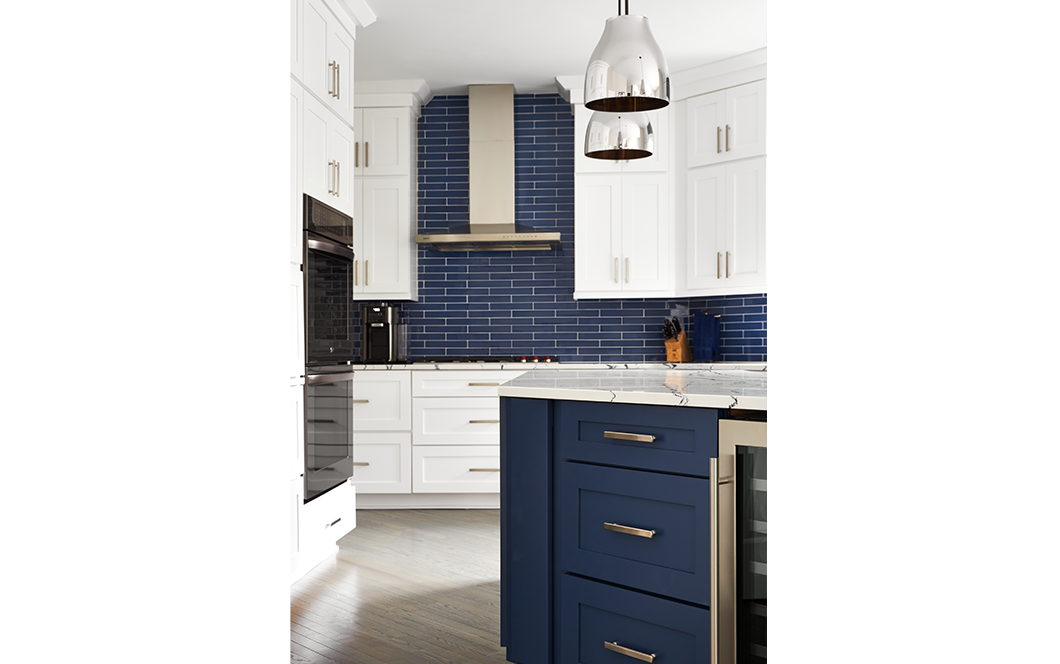 A custom kitchen remodel with blue subway tile backsplash, white cabinets, and granite countertops.