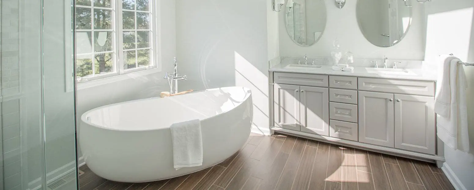 A bright, newly remodeled bathroom with white walls, a glass-framed shower, and a sleek bathtub in the corner