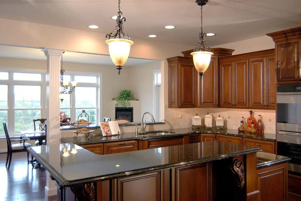 Kitchen remodel with dark brown wood cabinets and black countertops