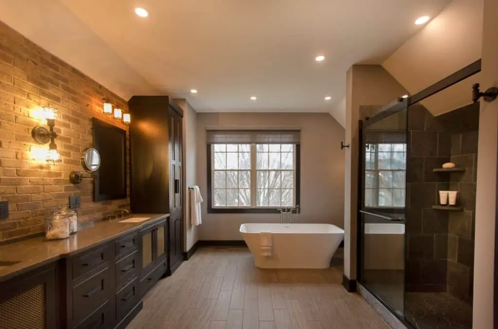 Large moody master bathroom remodel with stone tiling and a free-standing bathtub