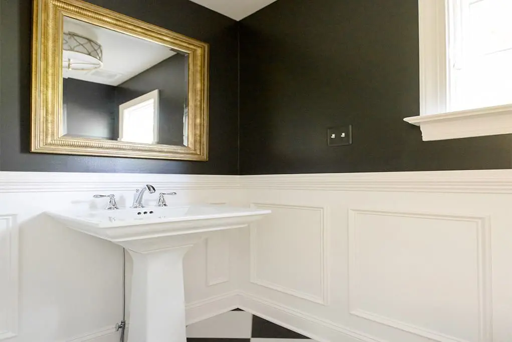 Black and white bathroom remodel with vintage gold mirror