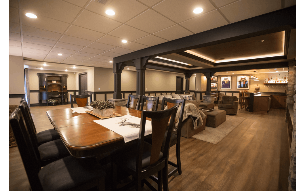 Expansive open-concept basement remodel with large dining area, movie/entertainment space, and fully-stocked mini-bar