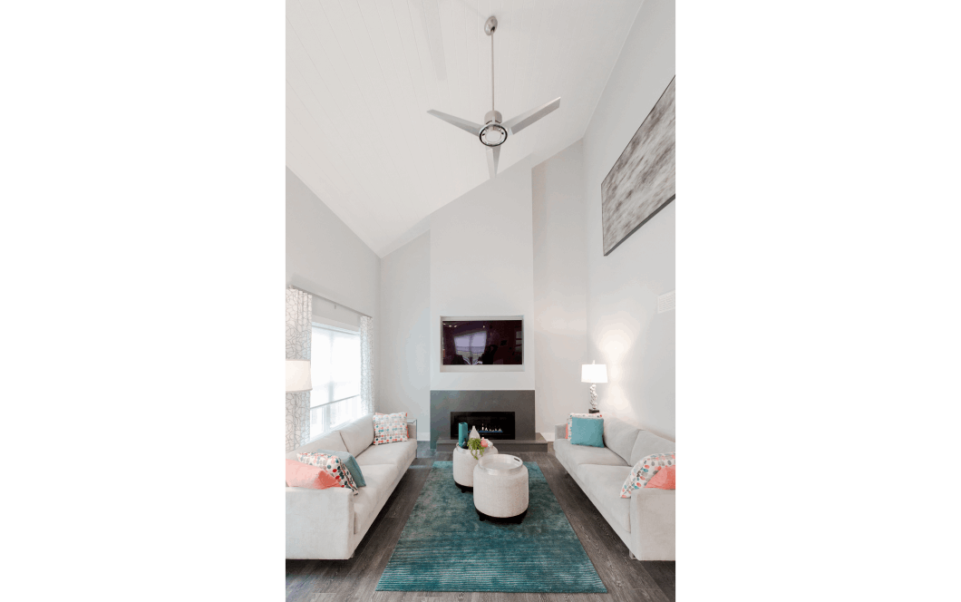 Open-concept two-story family room with large half-vaulted ceiling and modern grey fireplace