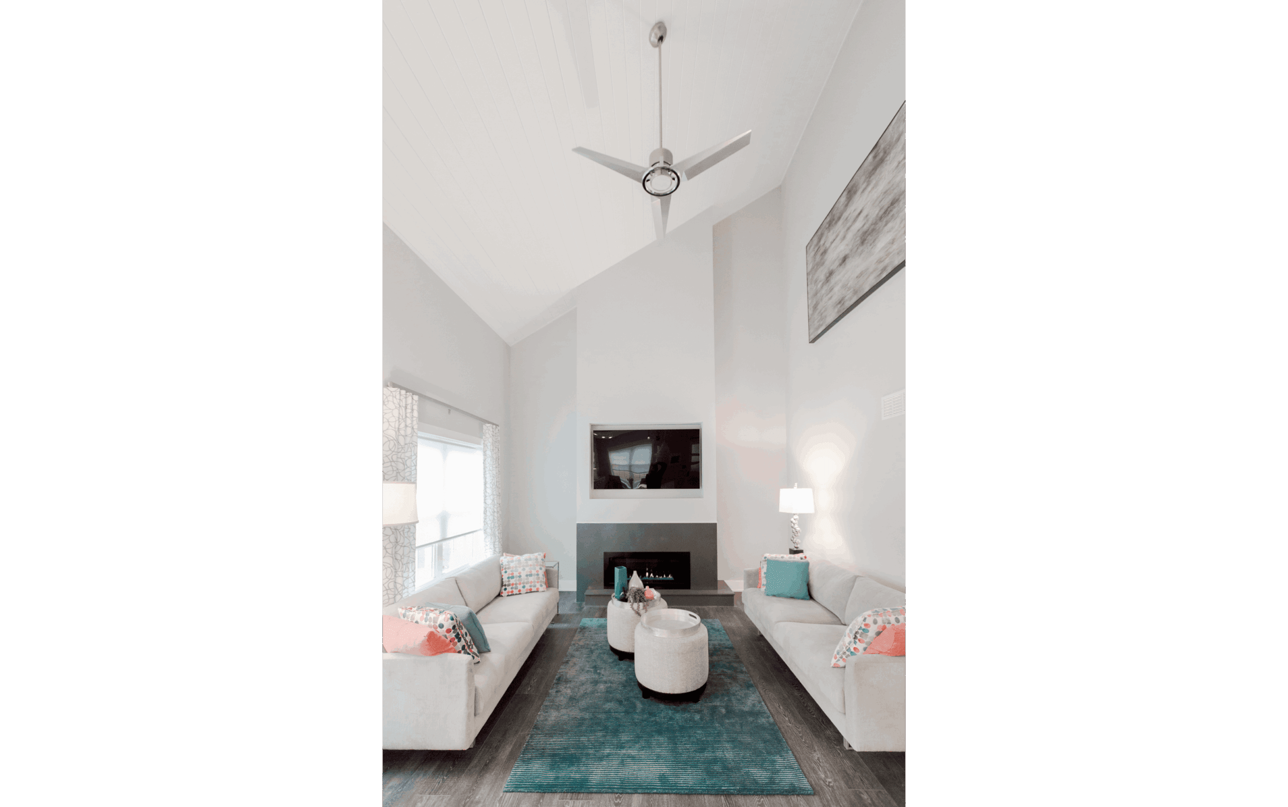 Open-concept two-story family room with large half-vaulted ceiling and modern grey fireplace