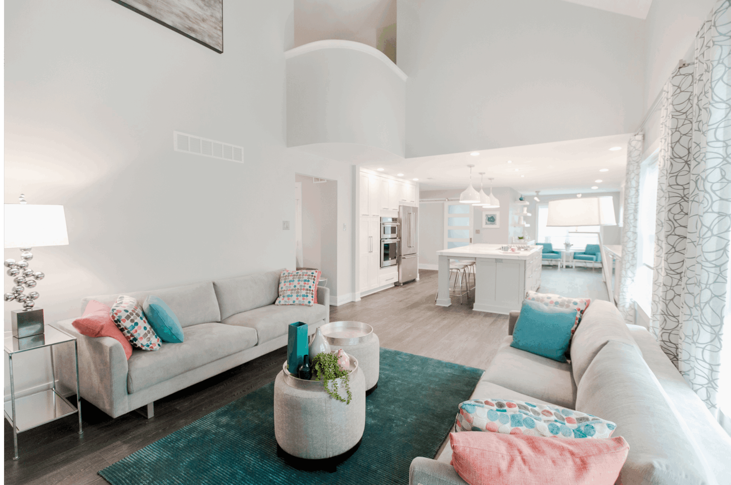 Open-concept two-story family room flowing into expansive kitchen and dining area