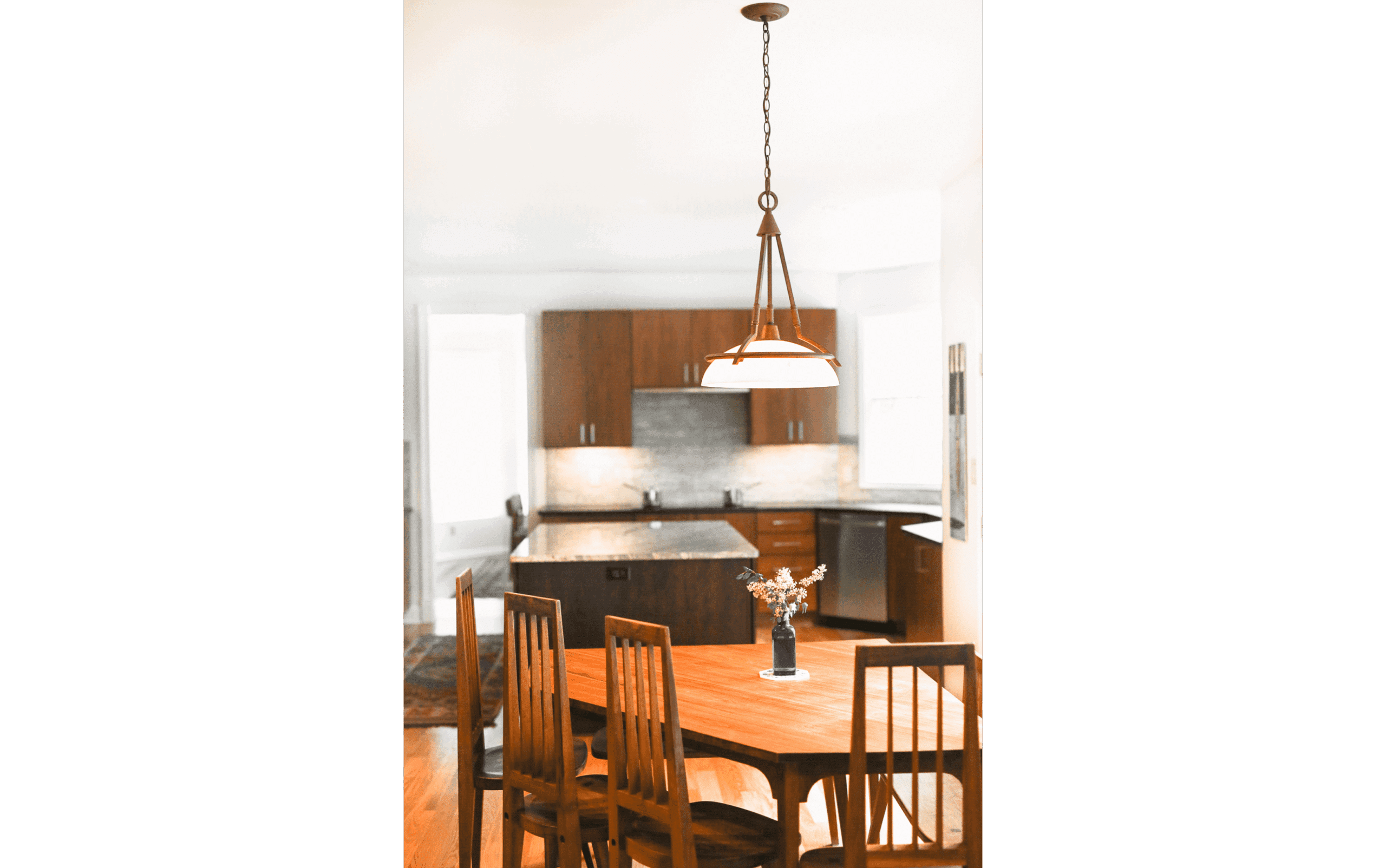Warm dining area with unique corner dining table overlooking modern renovated kitchen