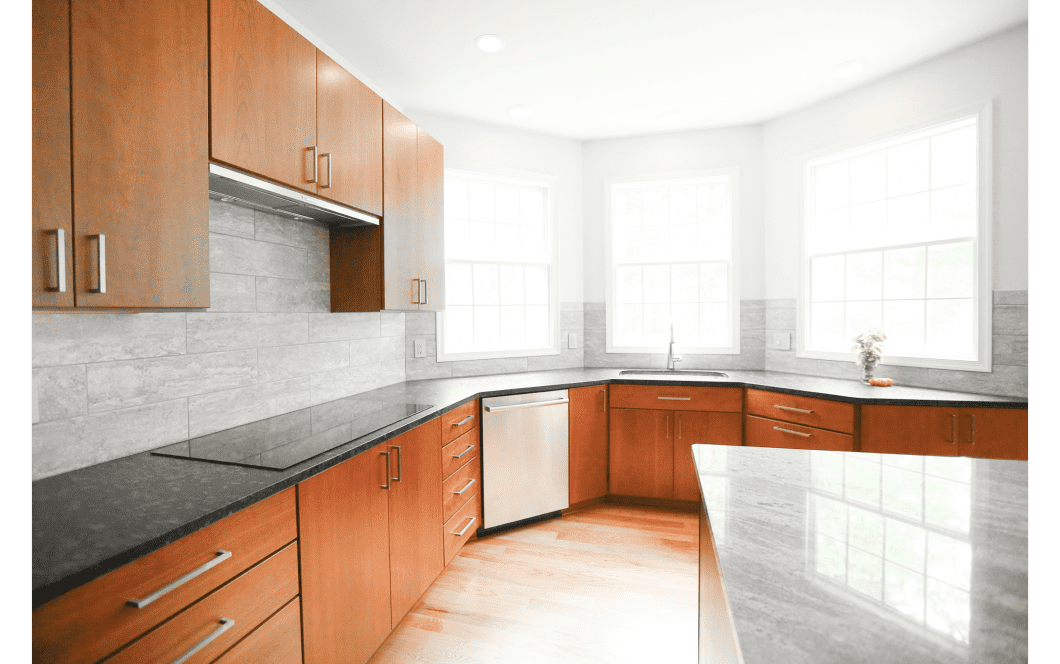 Modern kitchen with multiple windows and rich wood cabinetry