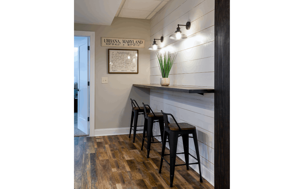 floating tabletop with rustic metal stools against grey shiplap wall