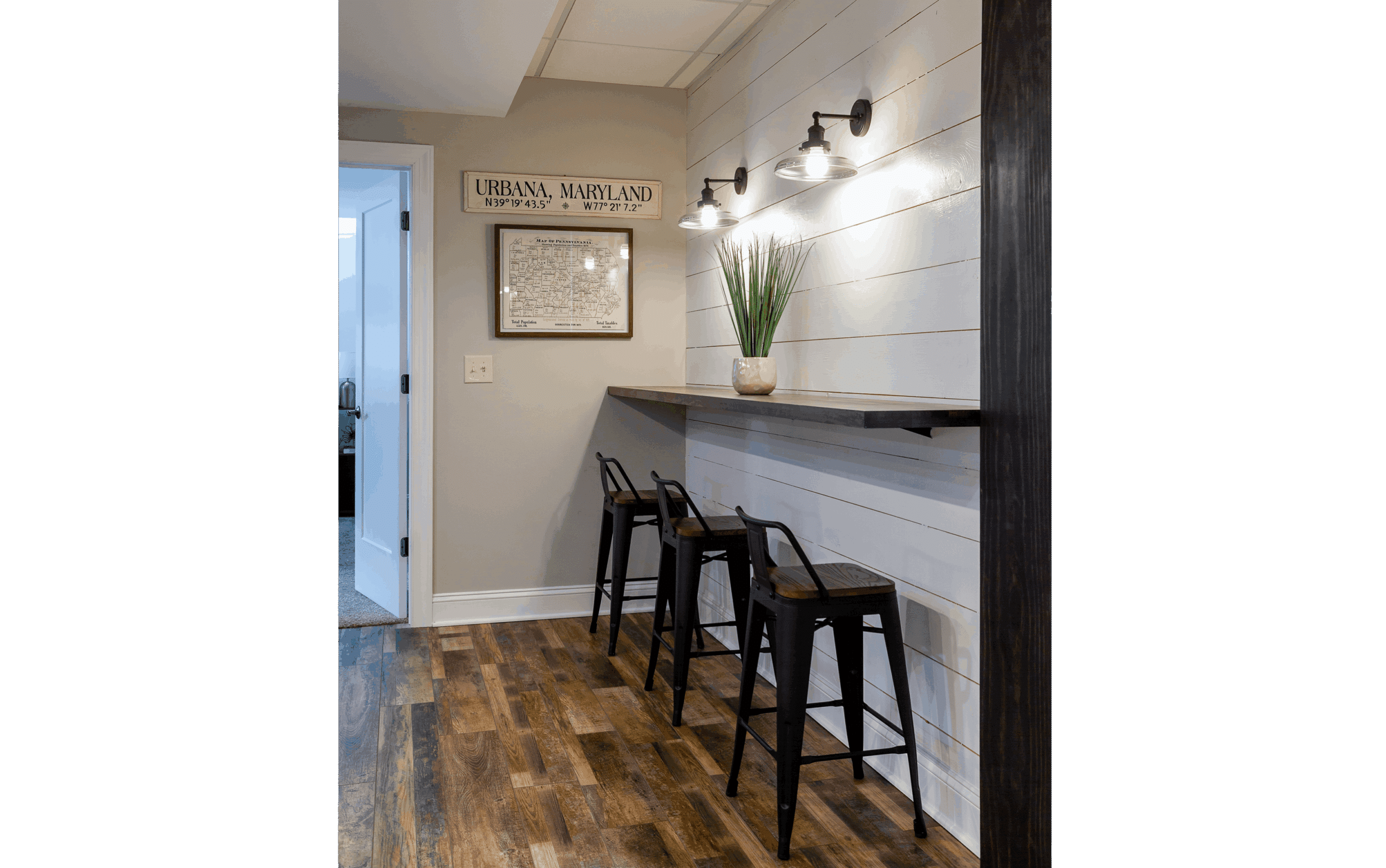 floating tabletop with rustic metal stools against grey shiplap wall