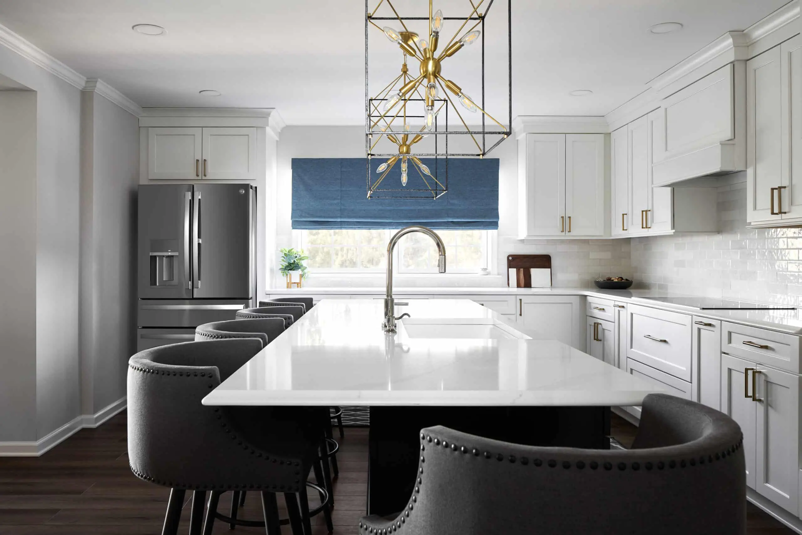 A custom remodeled kitchen with white textured tile backsplash, white cabinets, and white granite countertops.