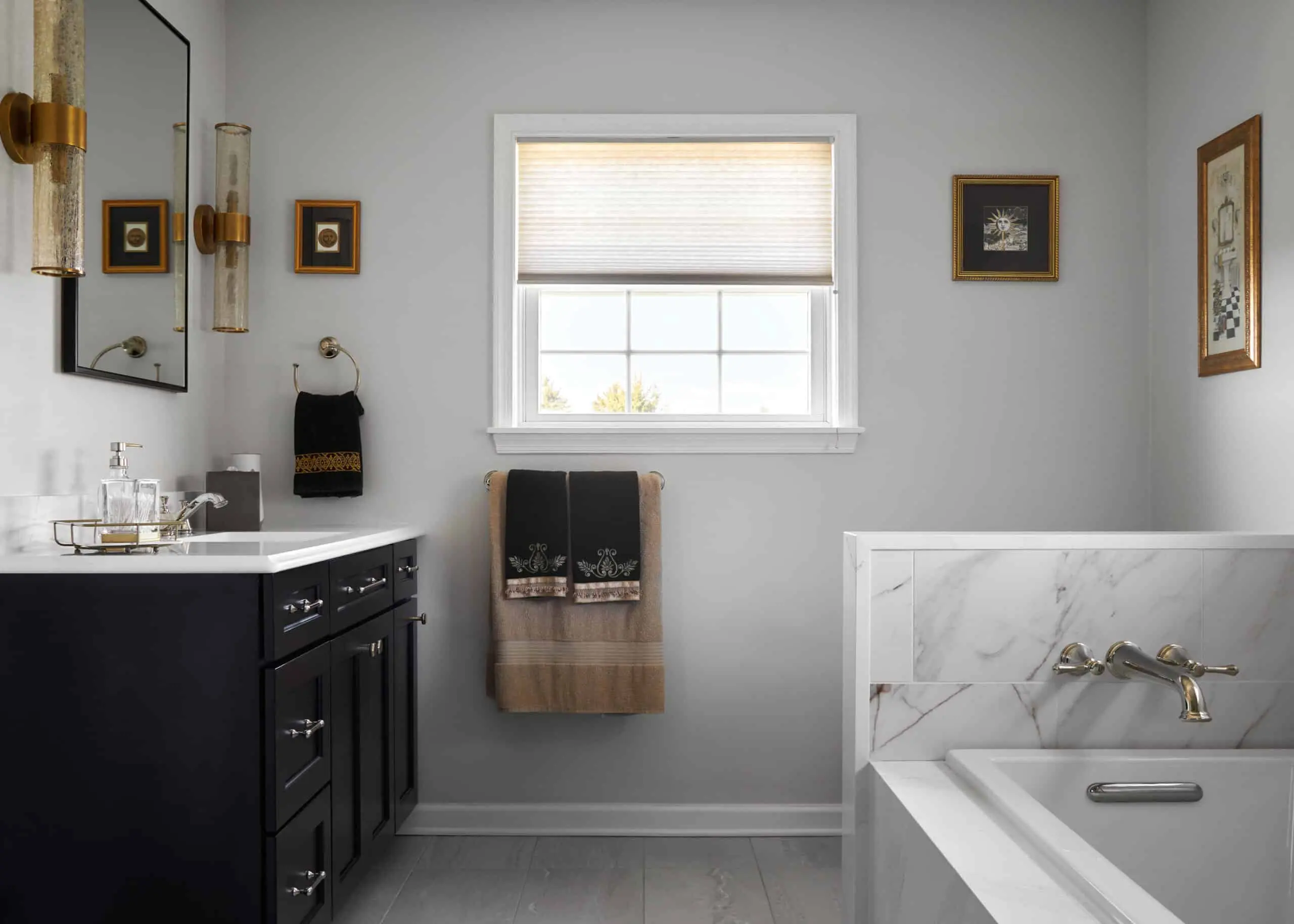 A bathroom remodel with dark cabinets, white marble countertops, and granite tiling.
