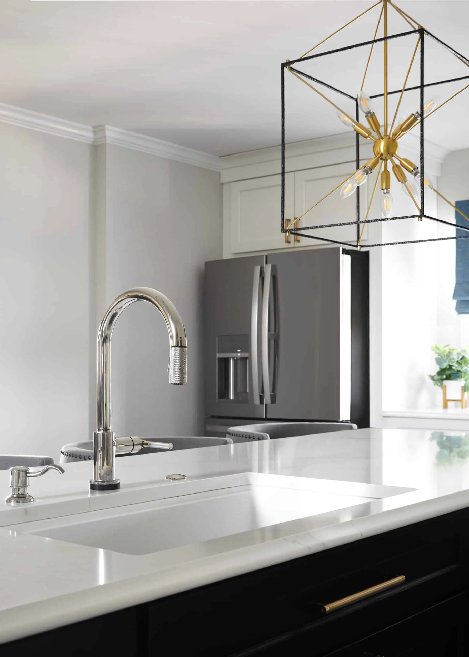 A redesigned kitchen with granite countertops and stainless steel sink faucet.