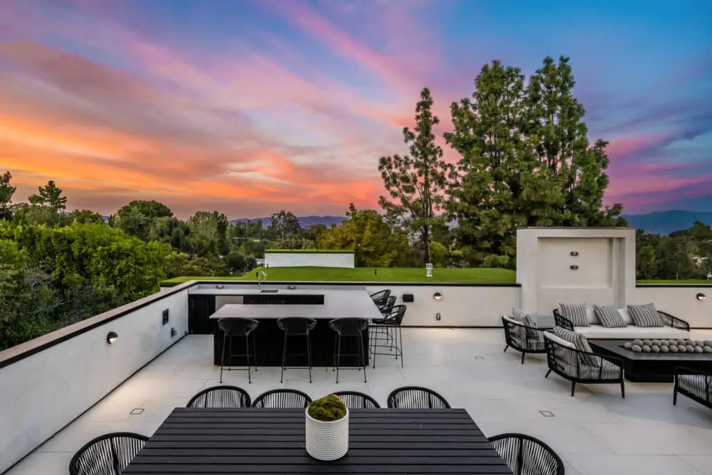 Scenic view of an outdoor patio surrounded by trees at sunset