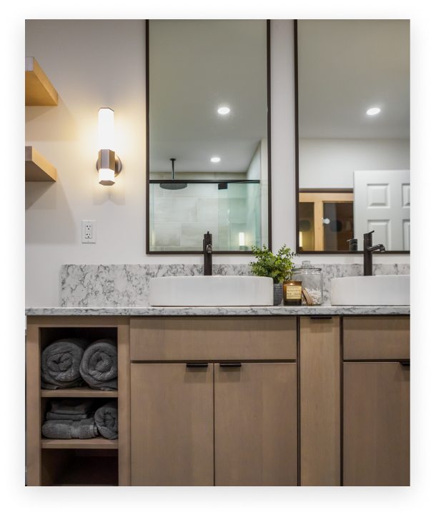 bathroom renovation tall double mirrors over granite countertops brown cabinetry