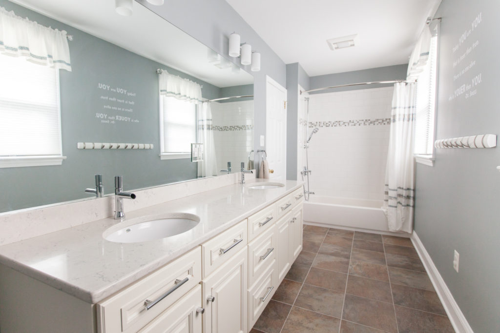 Bright white and gray bathroom remodel completed by Meridian Construction home remodelers.