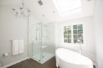 large bathroom with soaking tub and walk in glass shower