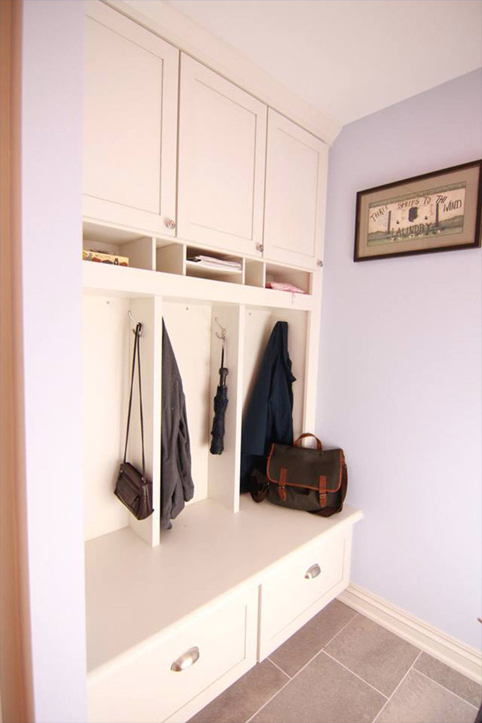 mudroom at entry point of house with built in cabinets and coat hooks