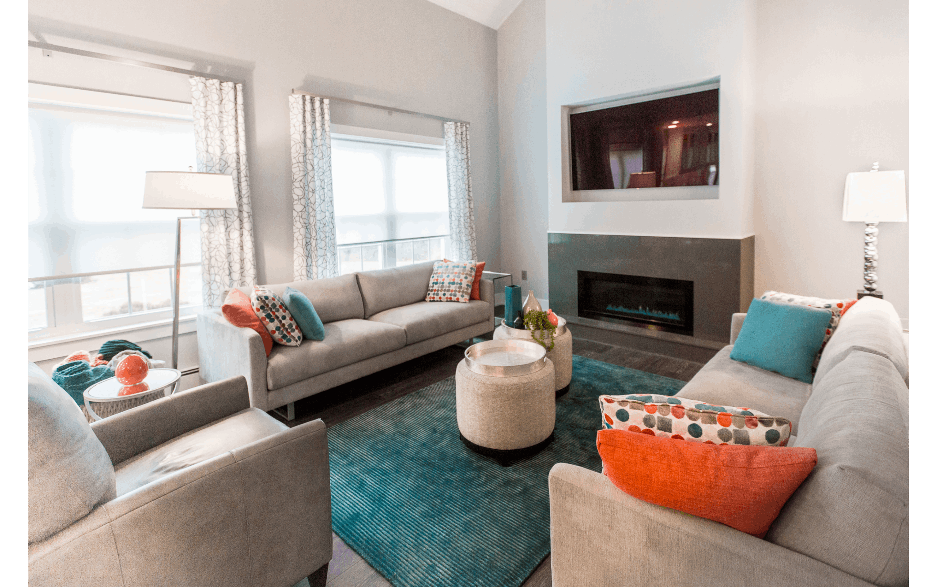 Large bright family room with two large picture windows and modern grey fireplace