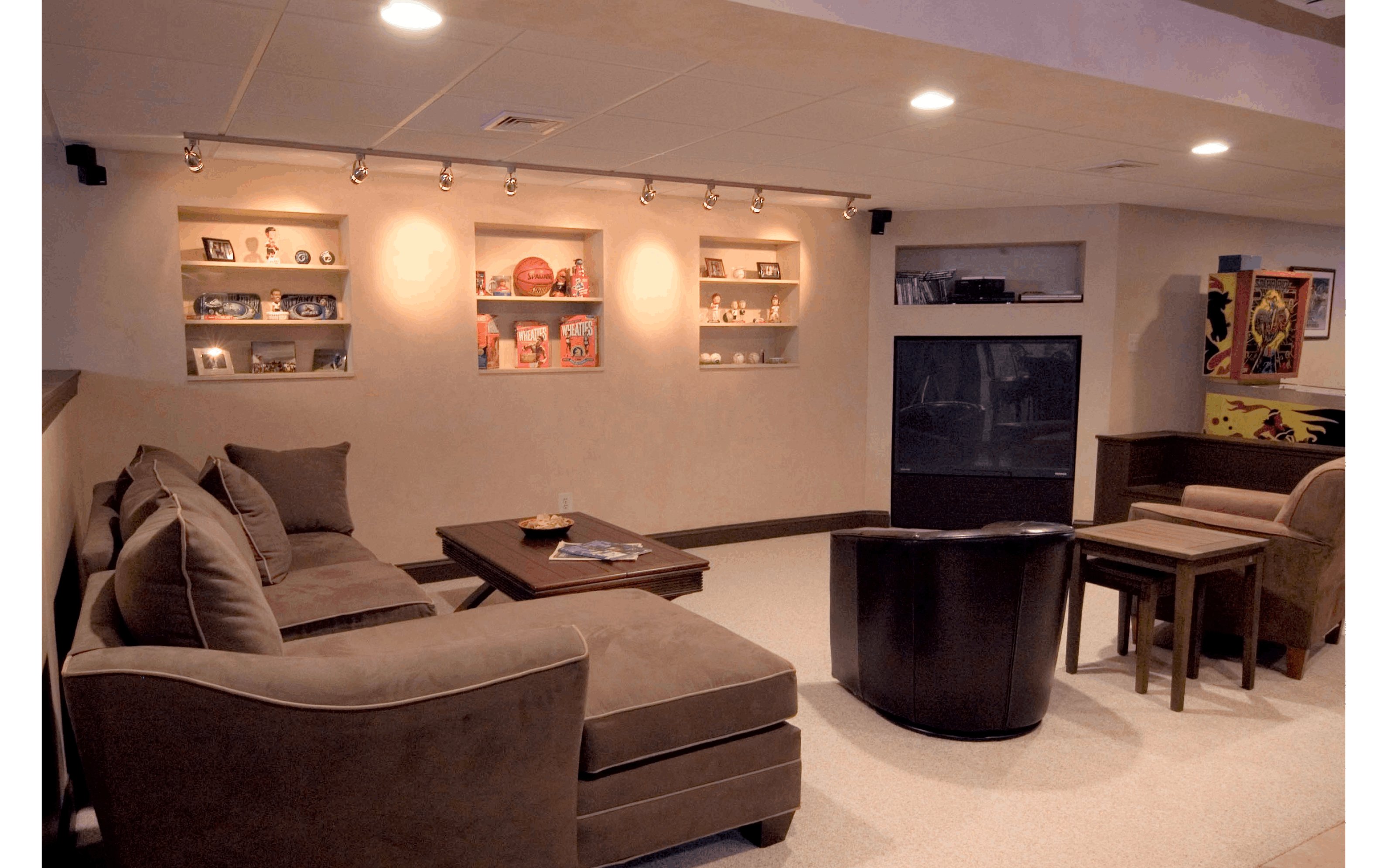 Sports bar basement remodel with shelves built into the walls and arcade games