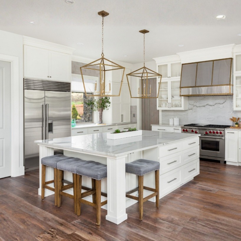 White kitchen with a large island and gold angular hanging light fixtures